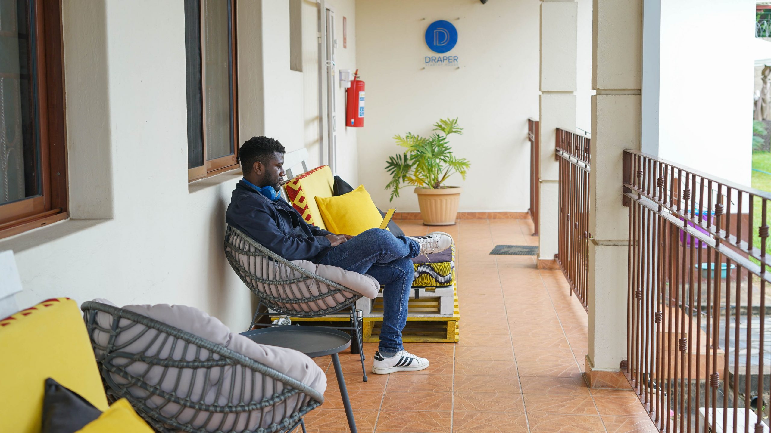 Image of man sitting at BongoHive wit Draper Startup House logo on the background